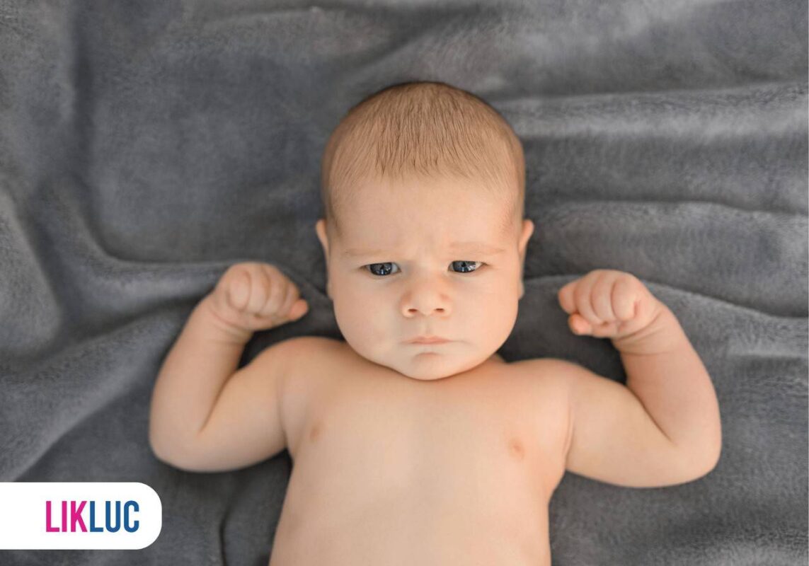 Bebê deitado em cobertor de cor cinza escuro