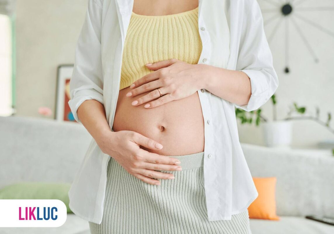 Detalhe de mãos na barriga de mulher grávida