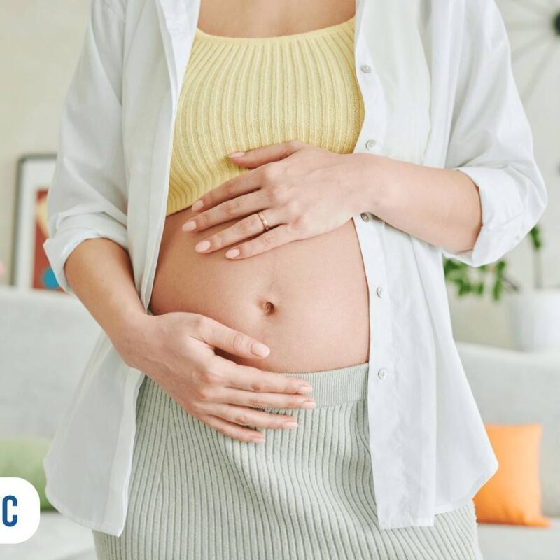 Detalhe de mãos na barriga de mulher grávida