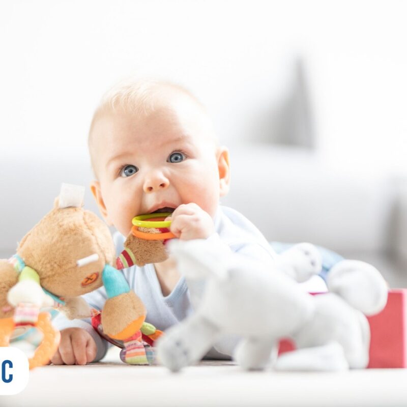 Bebê com brinquedo na boca