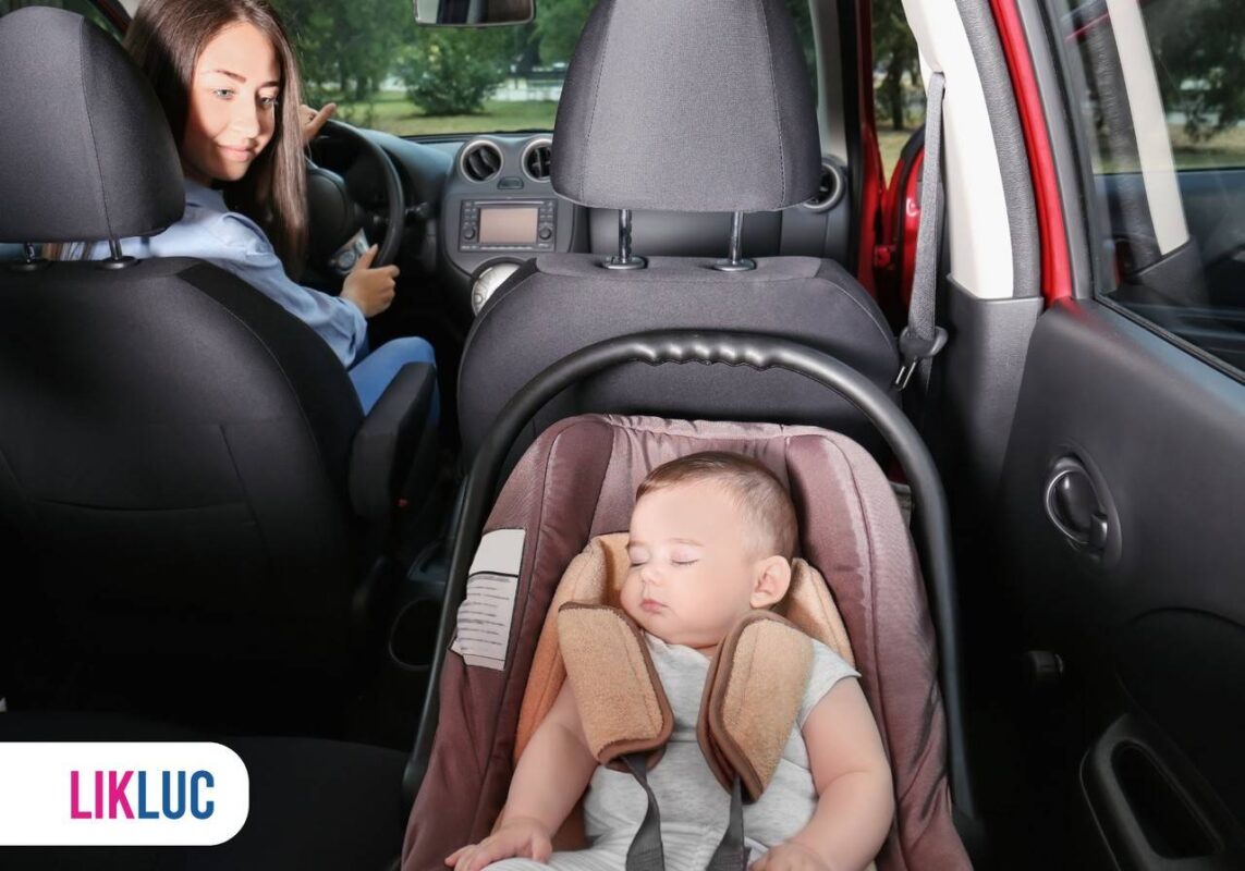 Mãe dentro do carro olhando para filho em bebê conforto instalado no banco de trás do veículo