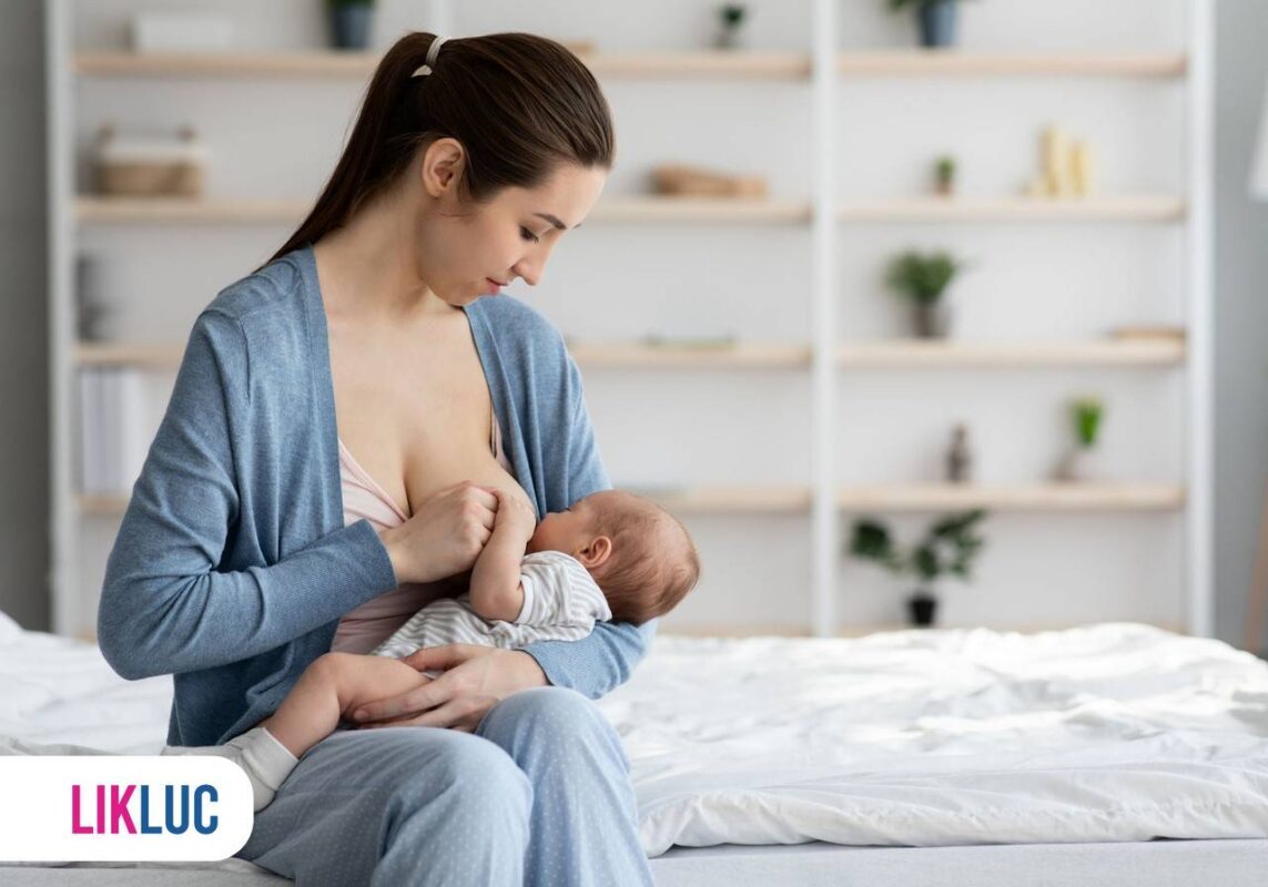 Mãe segurando bebê no colo e amamentando em dormitorio