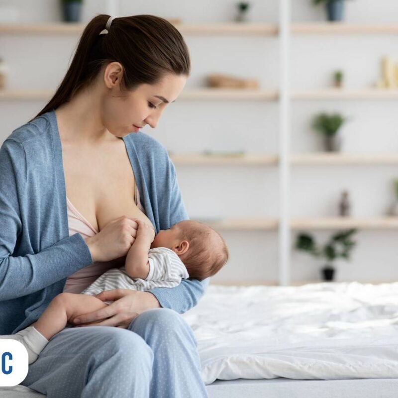 Mãe segurando bebê no colo e amamentando em dormitorio