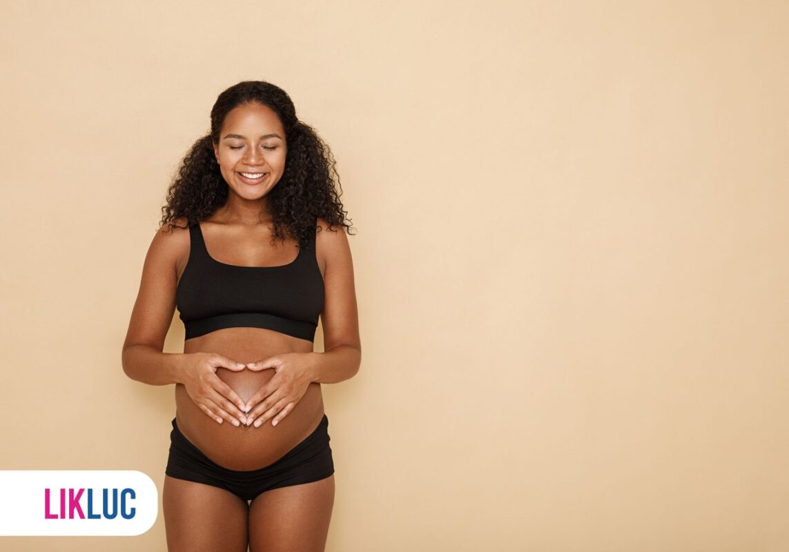 Mãe grávida segurando as mãos na barriga