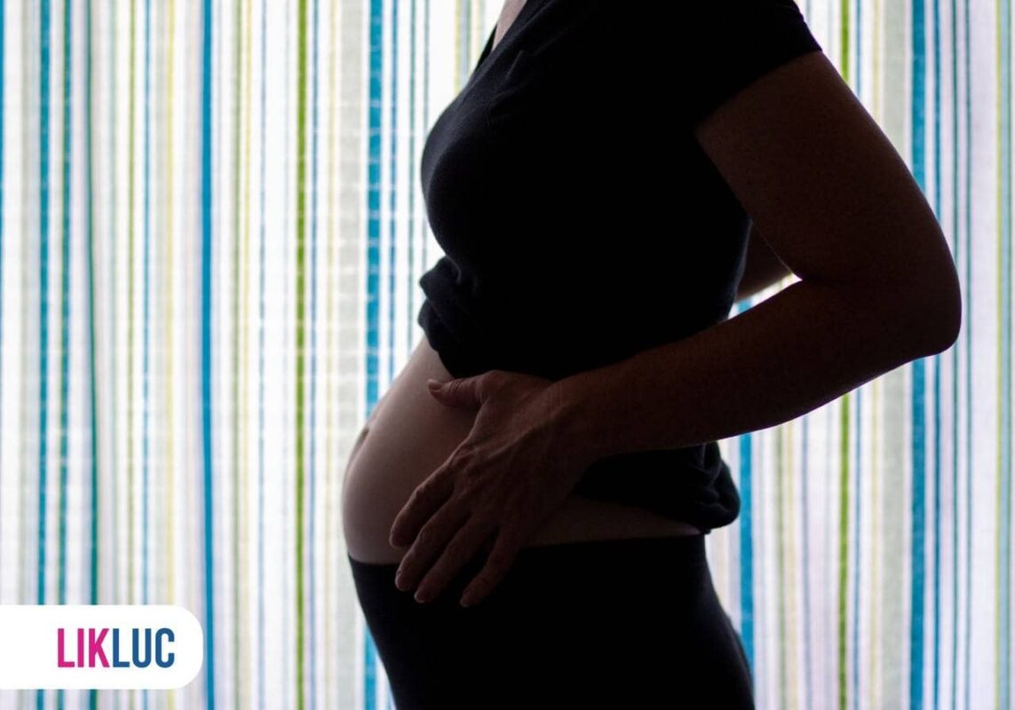 Mae gravida com a mao na barriga