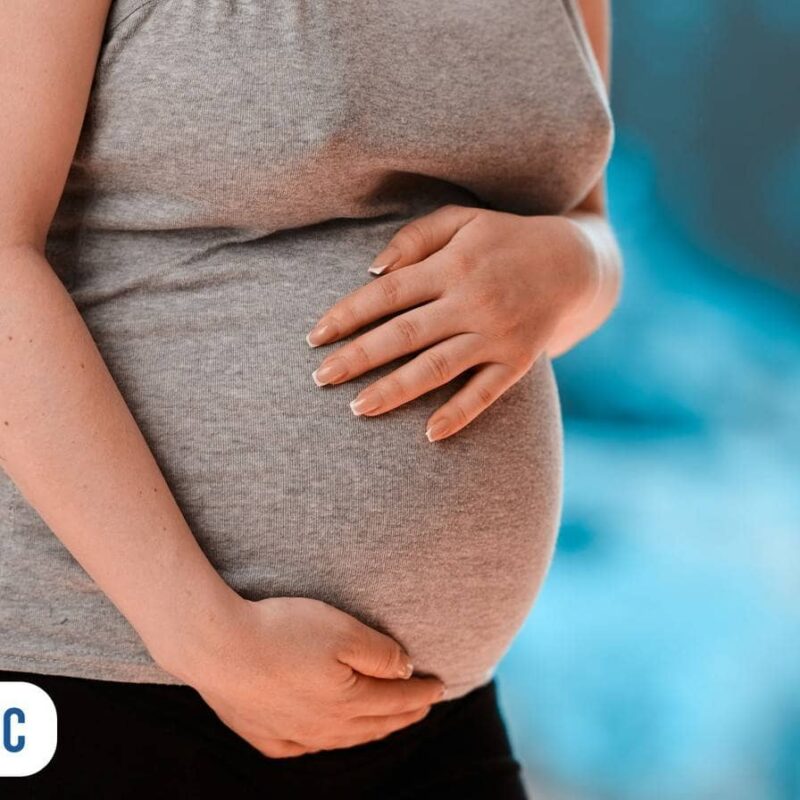 Gestante segurando a barriga ao sentir câimbras na gravidez