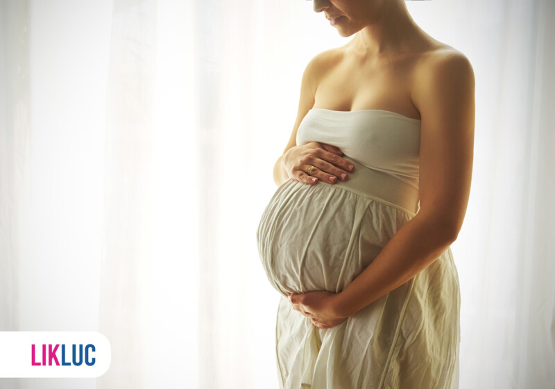 Mulher grávida com as mãos na barriga