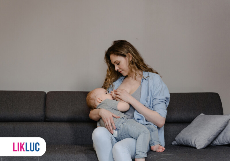 Mãe amamentando seu bebê em sofá aconchegante