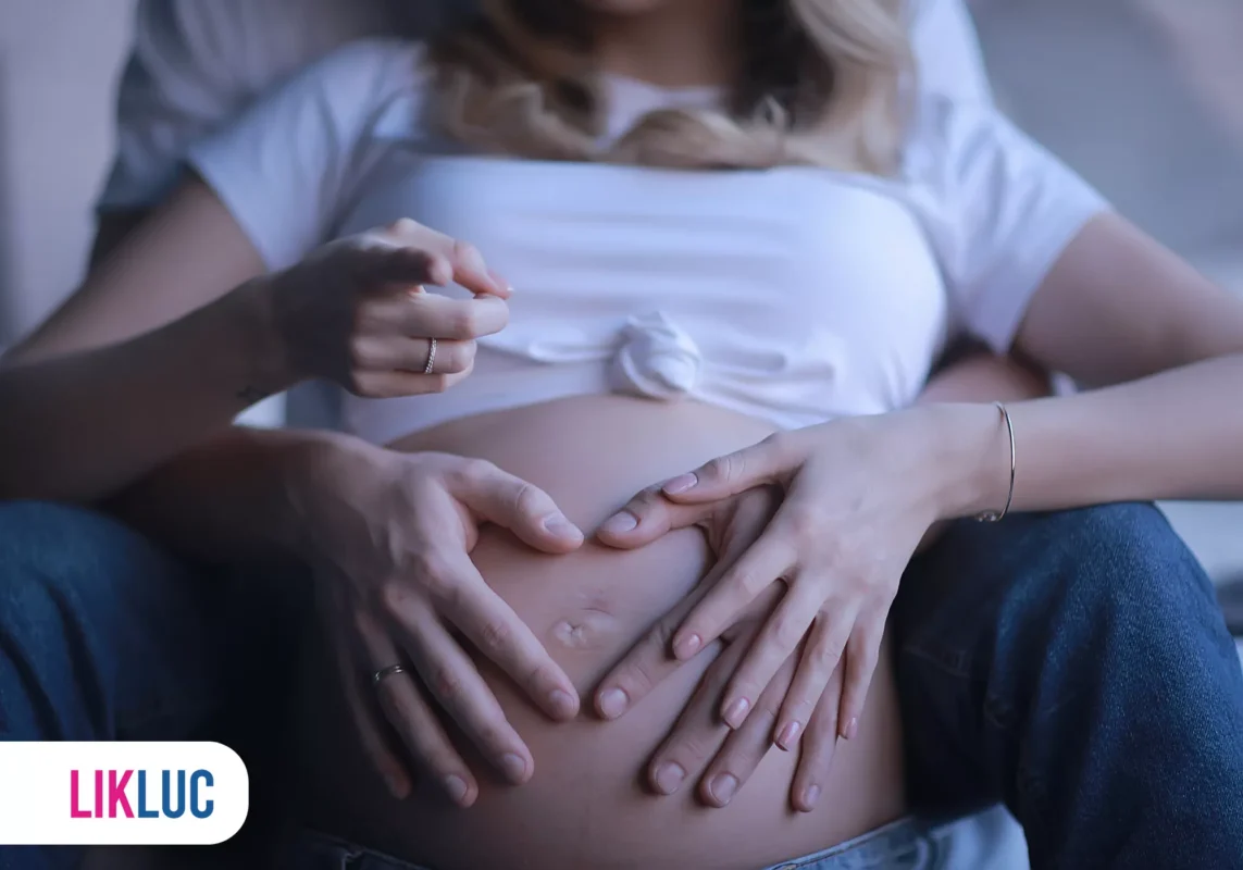 Casal mostrando a barriga da gravidez com carinho.