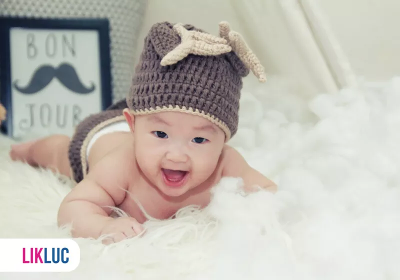 Bebê sorridente com chapéu em ambiente fofo