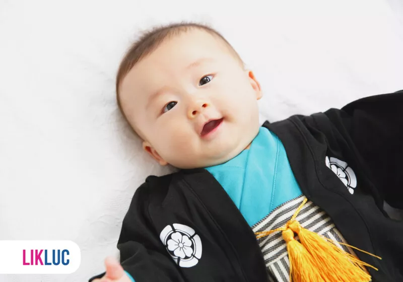 Bebê sorridente usando um traje tradicional japonês.