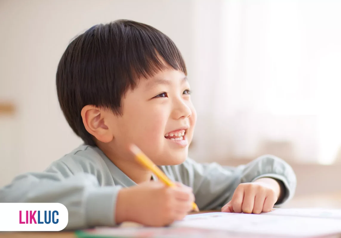 Criança japonesa desenhando com sorriso no rosto