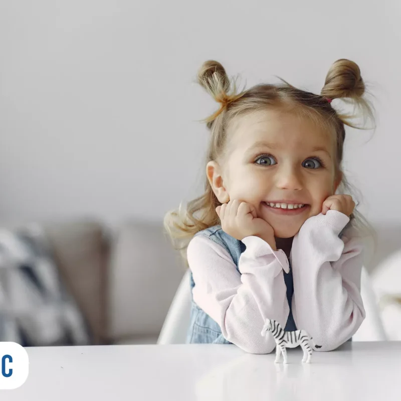 Criança sorridente com miniatura de zebra na mesa