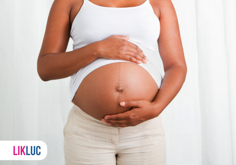 Mulher grávida com as mãos na barriga