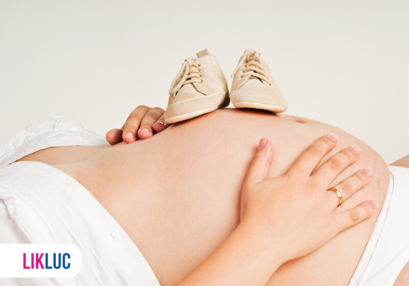 Barriga de gestante com sapatinhos de bebê