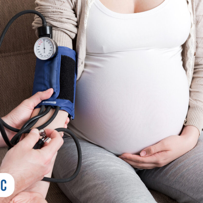 Gestante medindo pressão arterial em consulta médica