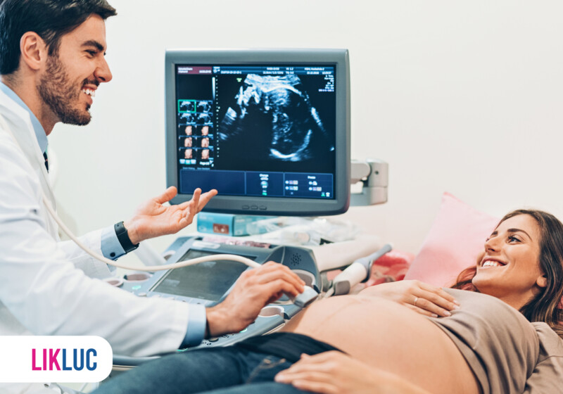 Ultrassom gestacional com médico e paciente sorrindo