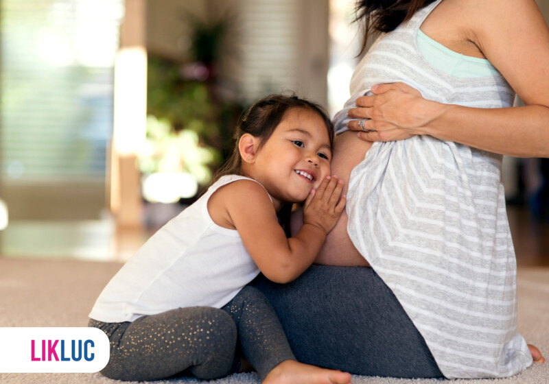 Criança abraçando a barriga de mãe grávida