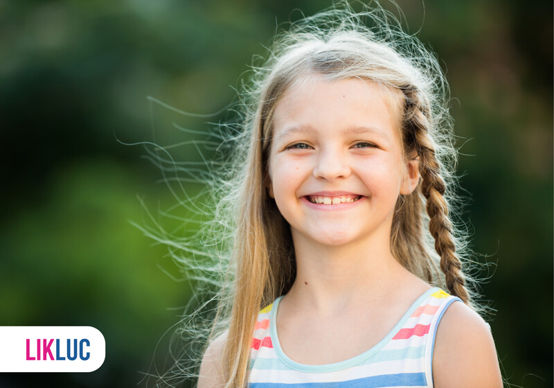 Criança sorridente com cabelo longo e trançado ao ar livre