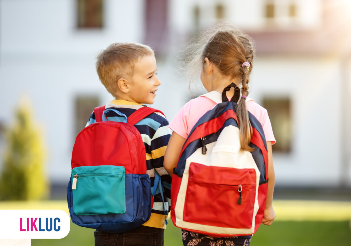Crianças felizes com mochilas coloridas ao ar livre