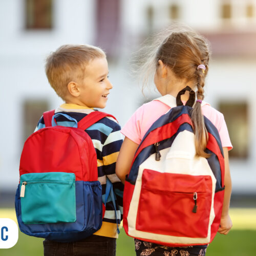 Crianças felizes com mochilas coloridas ao ar livre
