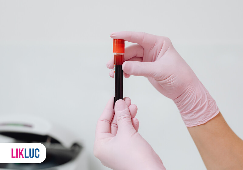 Mão com tubo de coleta de sangue em luvas