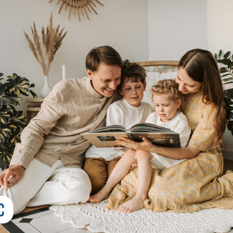 Família lendo um livro em ambiente aconchegante.