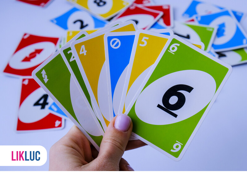 Mão segurando cartas de jogo Lik Luc
