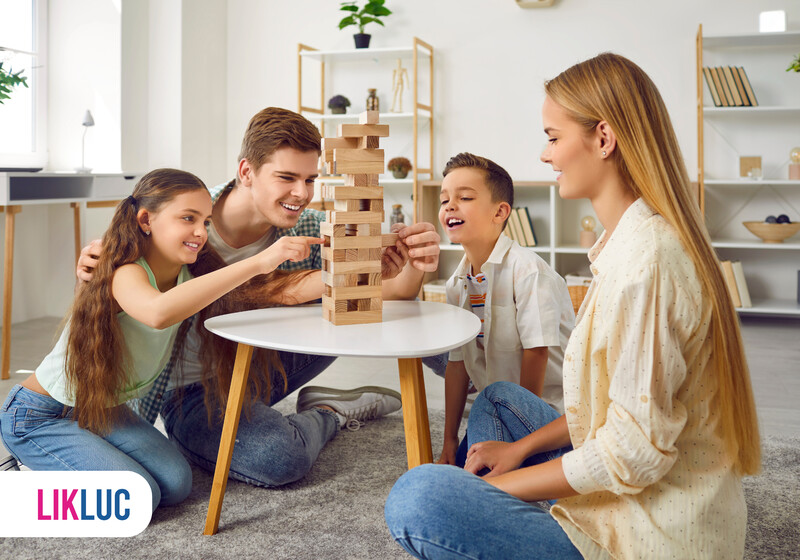 Família se divertindo com jogo de blocos em casa.
