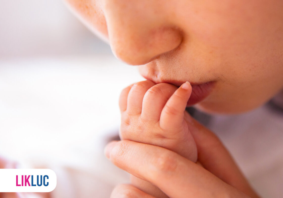 Mão de bebê segurando o dedo da mãe.