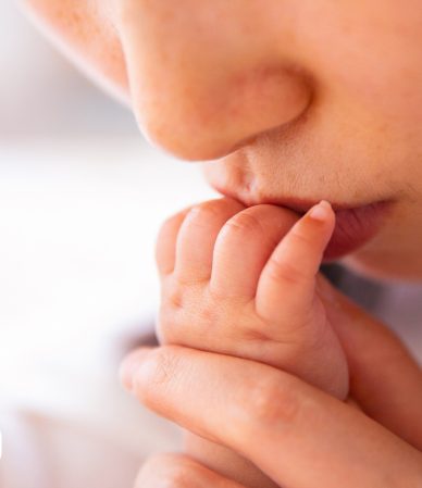 Mão de bebê segurando o dedo da mãe.