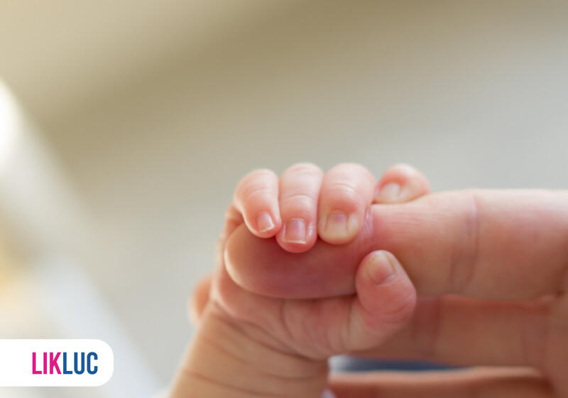 Mão de bebê segurando dedo de adulto