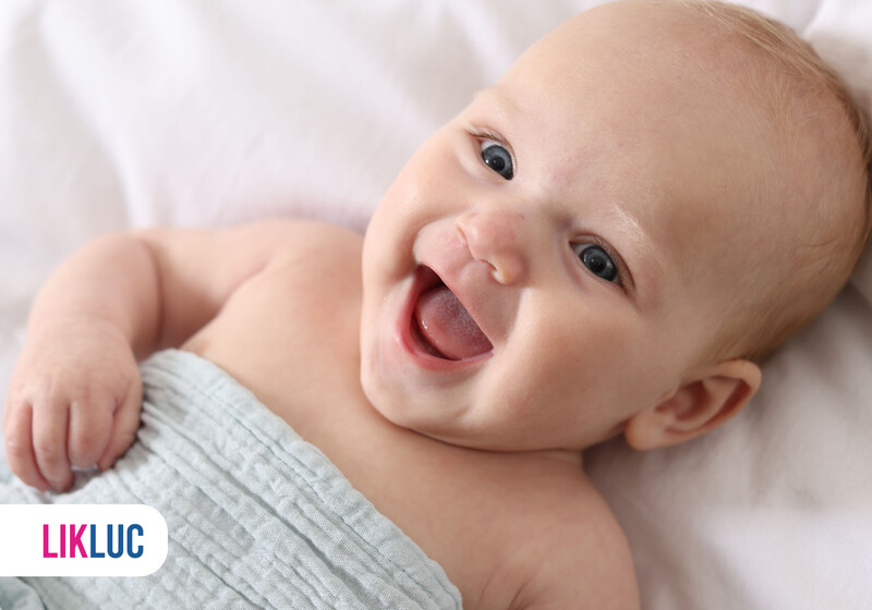 Bebê feliz sorrindo em cama macia
