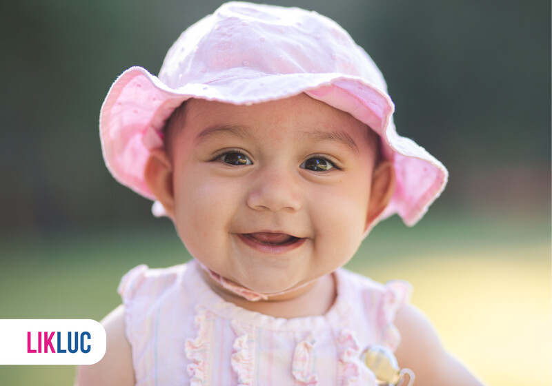 Bebê sorridente usando chapéu rosa