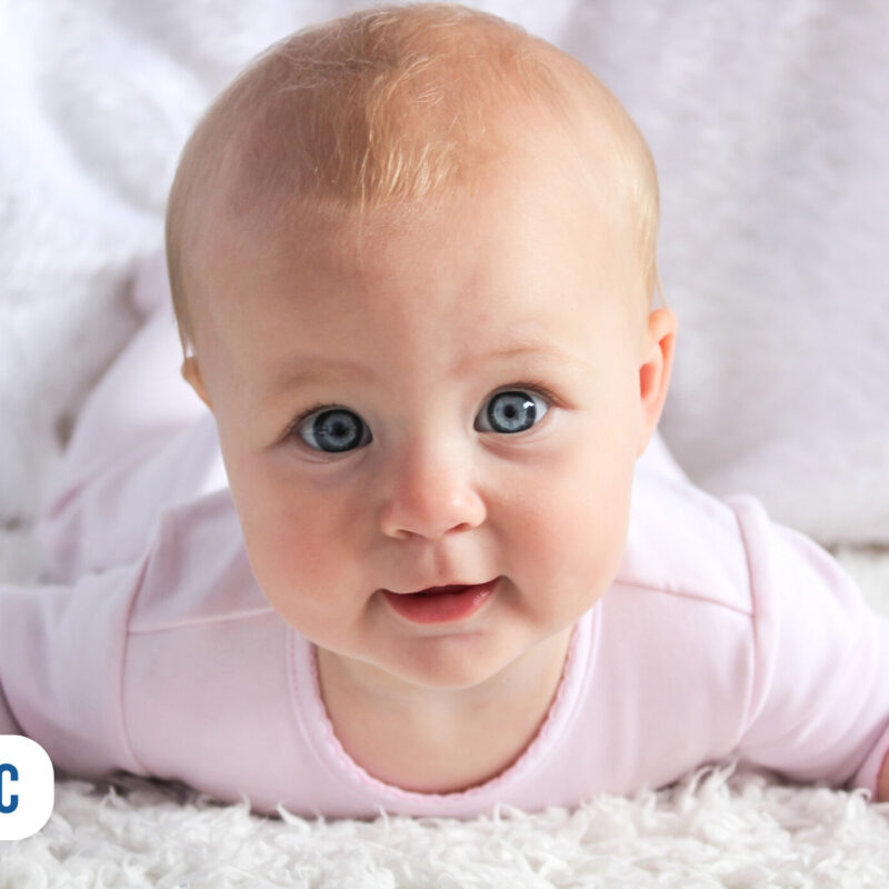 Bebê sorridente em superfície macia