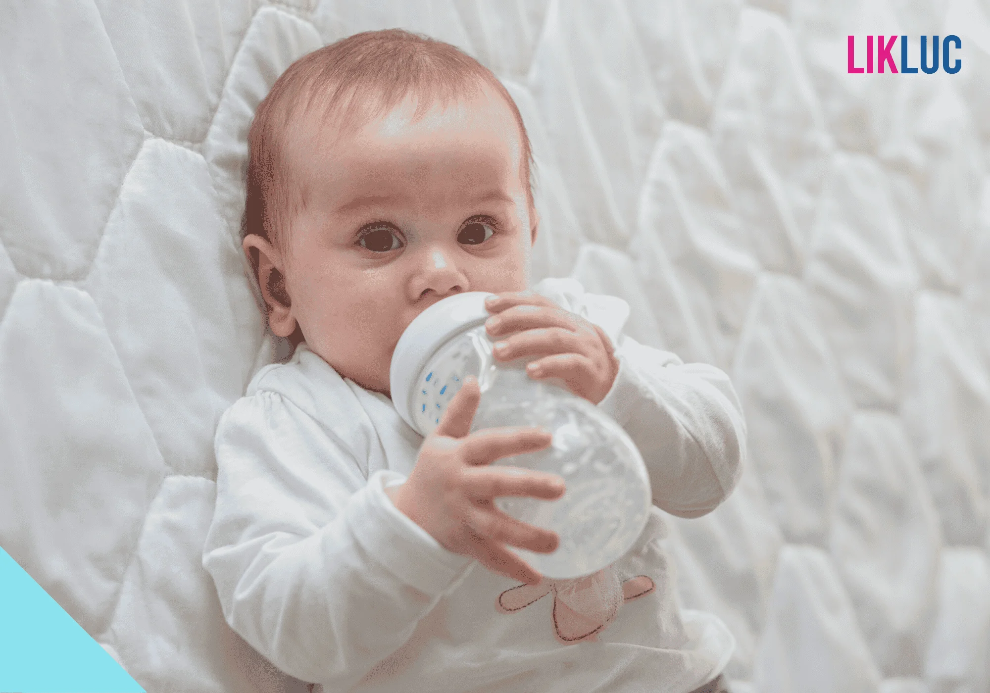 bebe segurando mamadeira