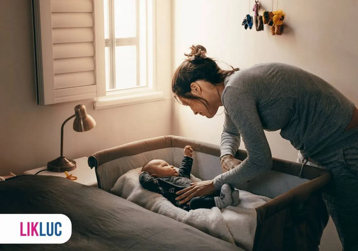 Mãe fazendo o bebê dormir no berço