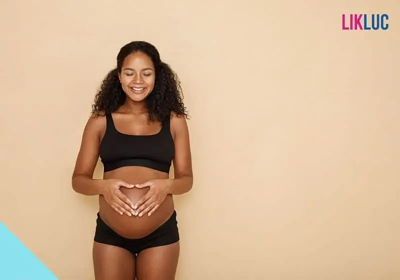 Gestante sorrindo com as maos na barriga opt Gestante sorrindo com as maos na barriga