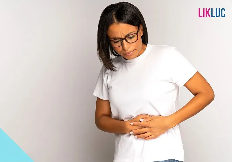 mulher segurando a barriga fazendo cara de desconforto