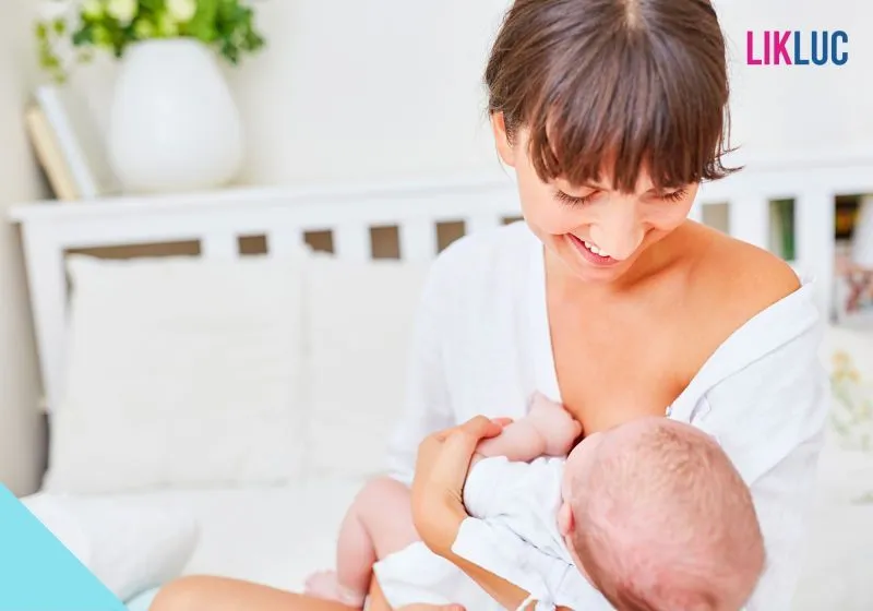Mãe amamentando seu bebê no colo e com roupas claras