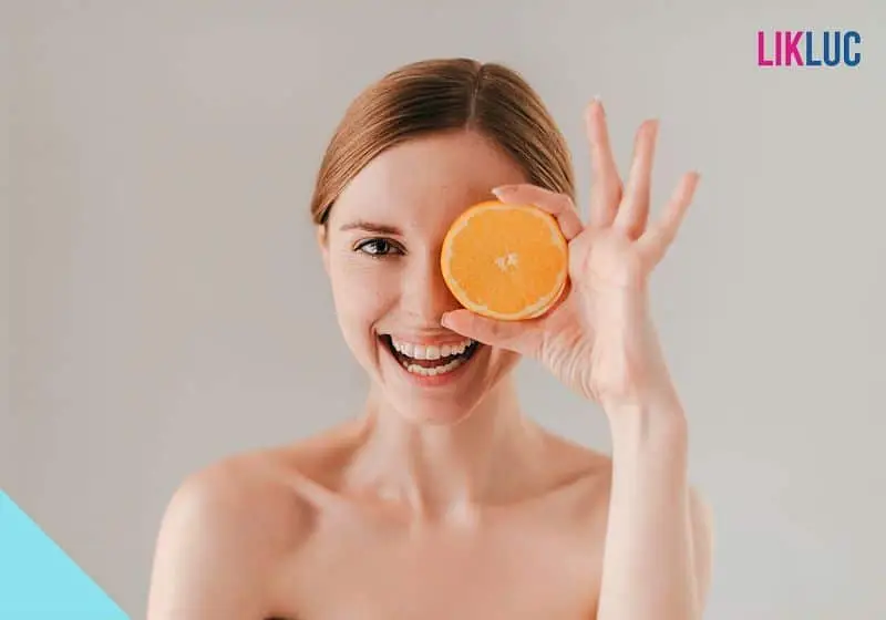 mulher com laranja na frente do rosto mulher com laranja na frente do rosto