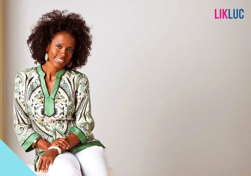 Mulher ao fundo branco sorrindo e olhando para a câmera