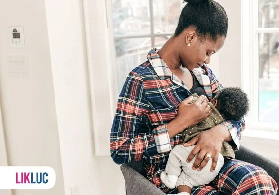 mãe olhando para o bebê enquanto amamenta.