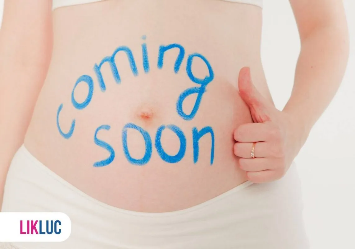 Imagem de uma gestante de 8 semanas com a frase escrita na barriga coming soon