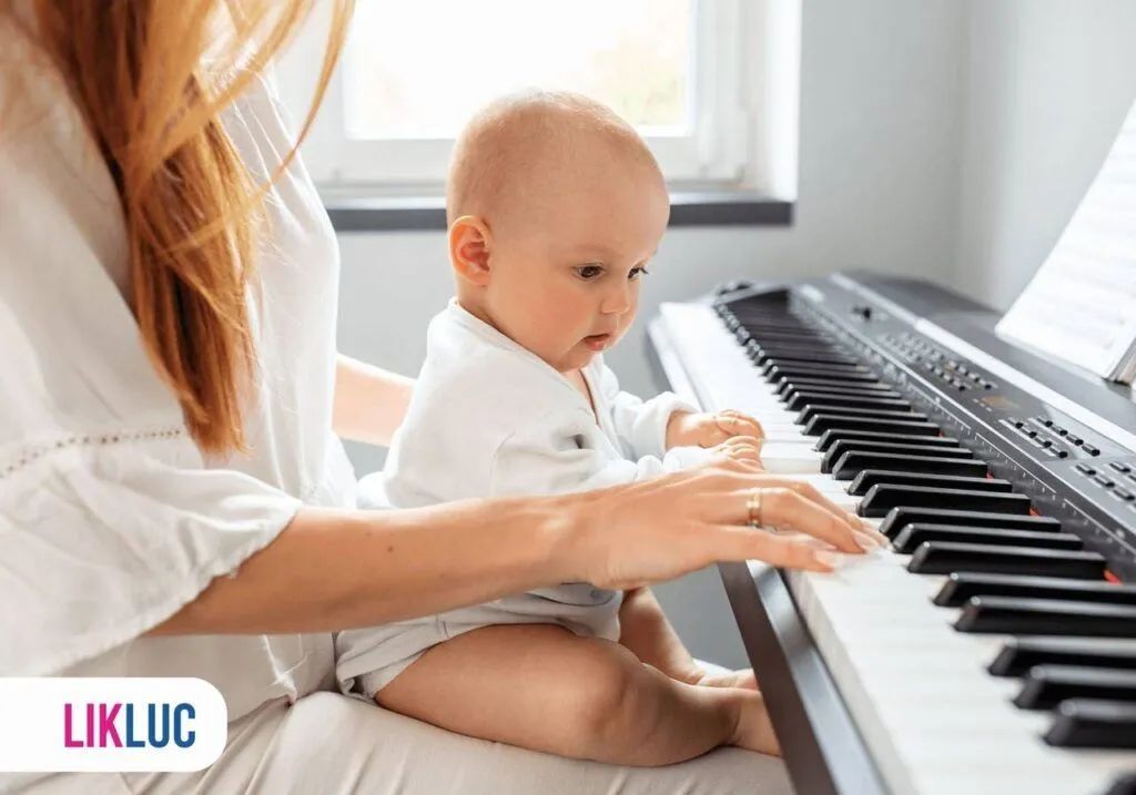 Bebê tocando piano no colo da sua mãe