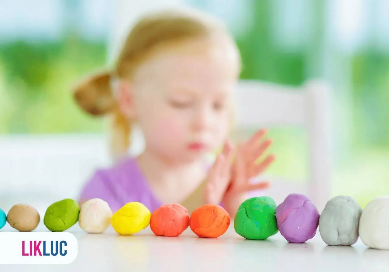 Vista de frente de bolinhas de massinha de modelar enfileiradas em cima de uma mes