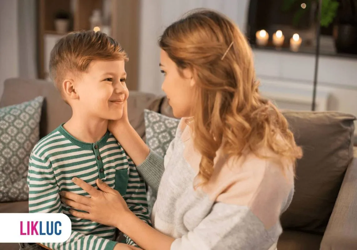 Mãe e filho sentados em sofá conversando entre si 