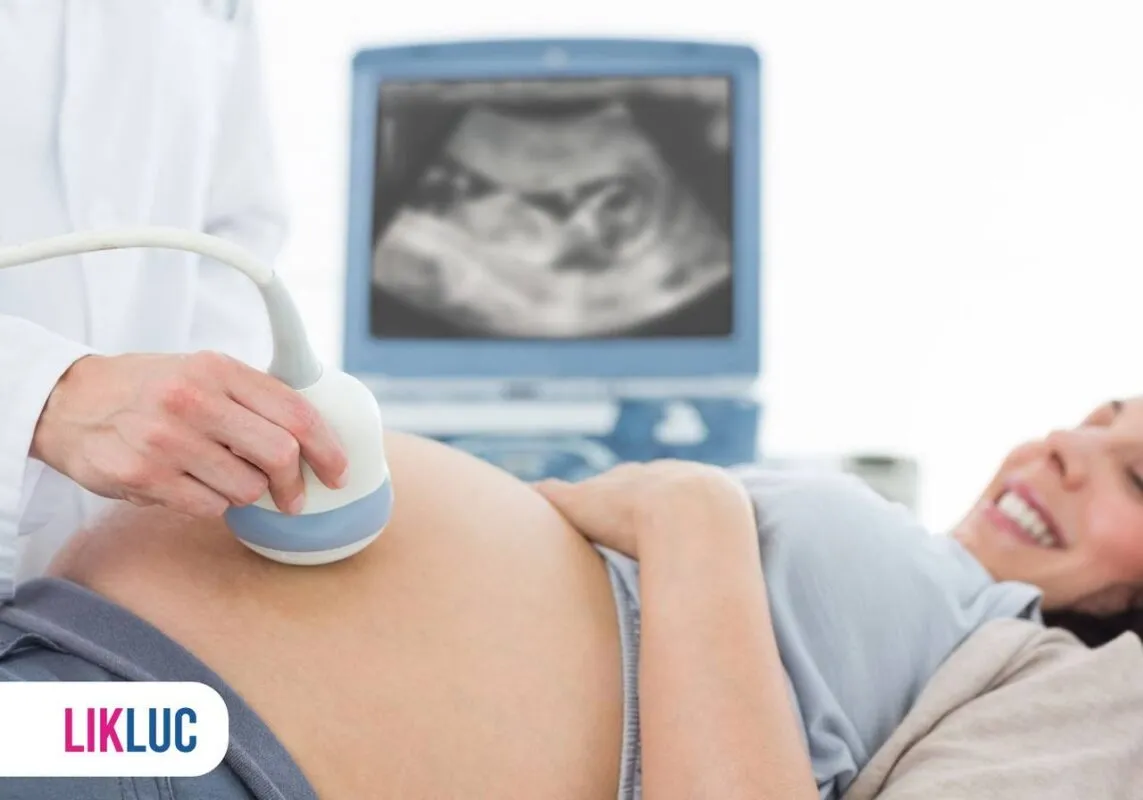 Grávida fazendo ultrassom com monitor de fundo