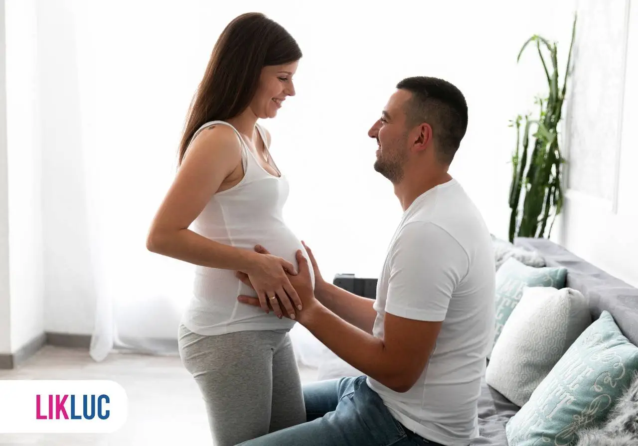 casal feliz com homem com mao na barriga da gestante