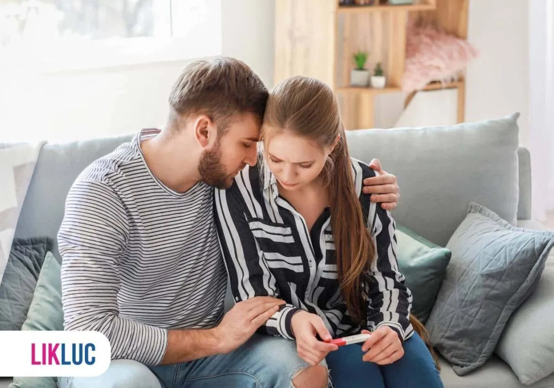 casal triste com teste de gravidez